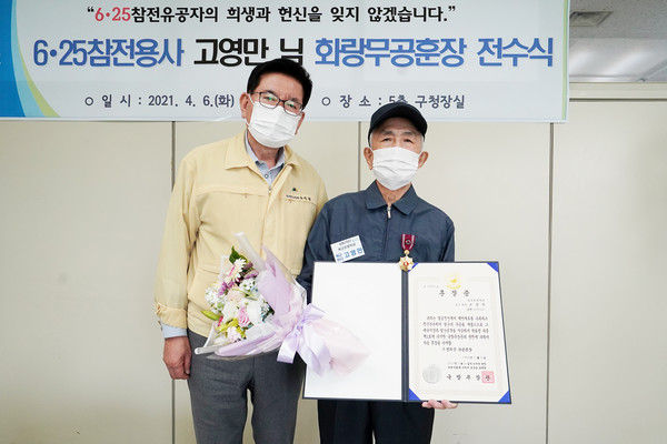 유덕열 동대문구청장(왼쪽)이 6․25 참전용사 고영만 하사(오른쪽)에게 화랑무공훈장을 전달하고 기념촬영을 하고 있다. /사진제공=동대문구