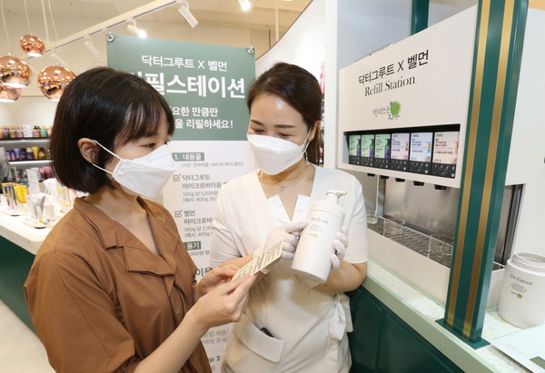 매장 직원이 ‘빌려쓰는지구 리필 스테이션’ 제품에 대해 소비자에게 설명하고 있다. /사진제공=LG생활건강