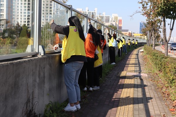 수원시 호매실동 매실교 투명방음벽에 야생조류 유리창 충돌방지 스티커를 부착하는 자원봉사자들 /사진제공=경기도
