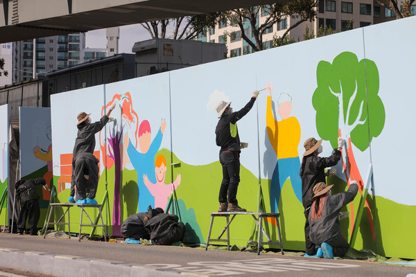 뚝섬한강공원 쓰레기적환장 가림막에 벽화를 그리는 자원봉사 대학생들 /사진제공=서울시