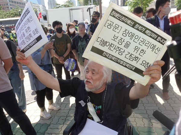 박경석 전장연 상임공동대표는 장애인권리예산 증액을 위한 국민의힘, 더불어민주당 간담회 요청 내용을 적은 종이를 들어올리고 있다. /사진=김인성 기자