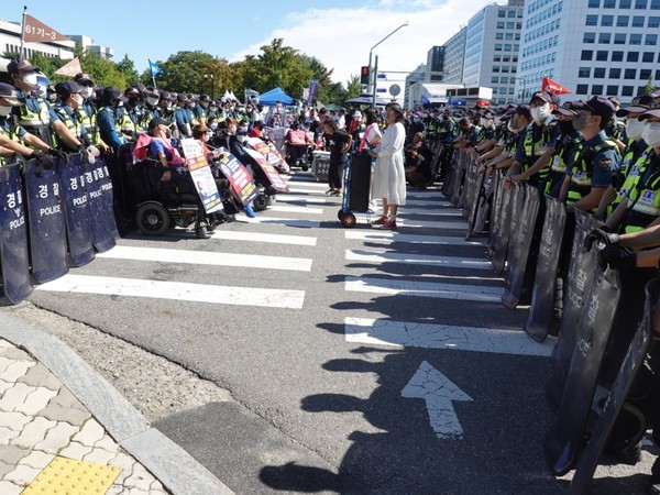 국회의사당 앞에서 시위하는 전장연 회원들과 대치한 전경들