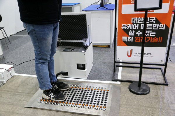 업체 관계자가 유케어매트(U-CARE MATE) 사용법을 시연하고 있다.