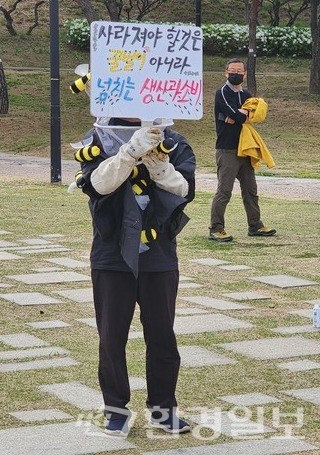 ‘사라져야 할 것은 꿀벌이 아니라 넘치는 생산과 소비’라는 푯말을 들고 서 있는 단체 회원 /사진=박선영 기자