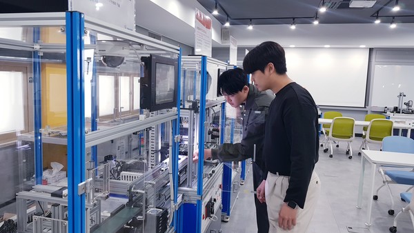 한국폴리텍대학 구미캠퍼스 AI전자과 학생들이 스마트팩토리 시스템에서 제품의 불량 여부를 확인하는 비전검사 공정을 학습하고 있다. /사진제공=고용노동부