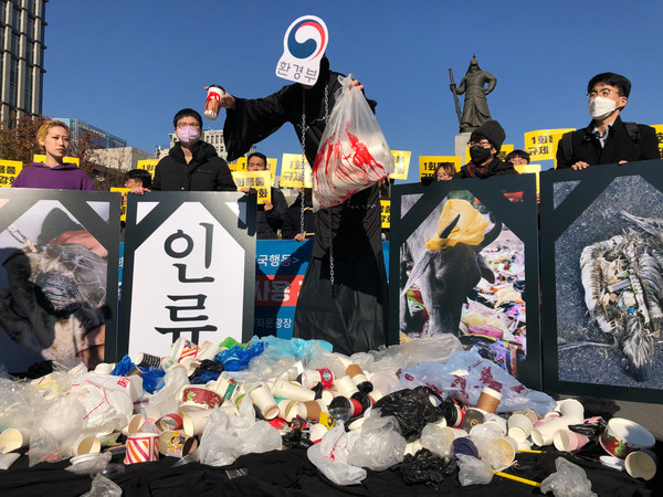 서울 광화문광장에서 진행된 기자회견에서는 환경부 가면을 쓴 사신과 1회용품으로 죽어가는 동물/사람의 영정사진이 시민들이 모아준 1회용품 쓰레기에 둘러싸여 있는 모습을 구현했다. /사진=녹색연합