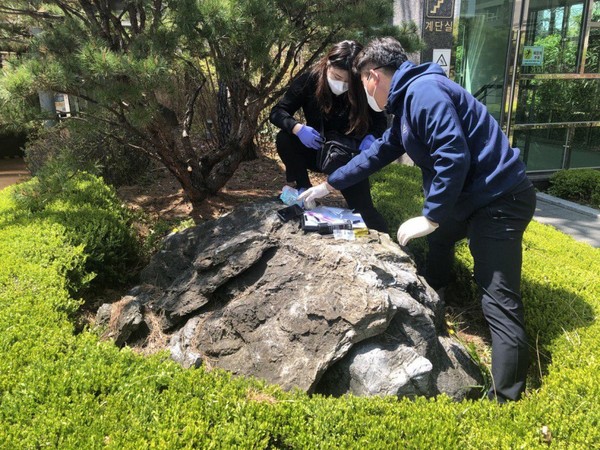 환경부 산하 한국환경공단 관계자들이 석면이 검출된 인천 아파트 조경석에서 시료를 채취하고 있다 . /사진제공=환경보건센터