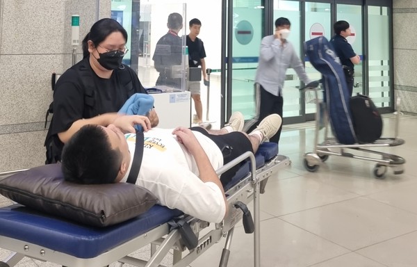 지난 25일 환자이송침대에 실려 인천국제공항 입국장 들어서는 백씨 /사진제공=성남시