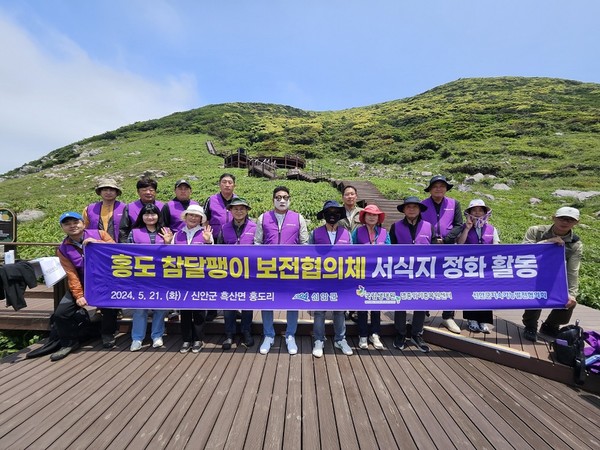 홍도 참달팽이 보전협의체 회원들이 서식지 정화활동 후 기념촬영을 하고 있다. /사진제공=신안군