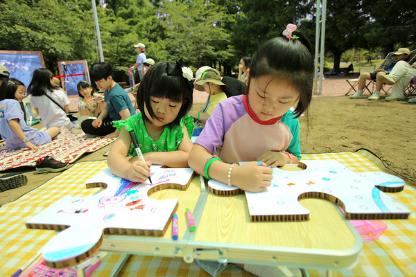 깨끗하고 건강한 바다를 주제로 참가 어린이들이 직접 그린 퍼즐 조각을 가로 6m, 세로 2.7m 크기의 퍼즐판에 붙이고 있다. /사진=그린피스