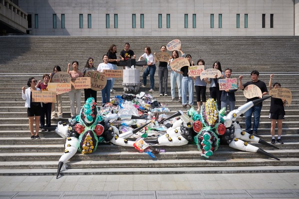 플라스틱 쓰레기와 플라스틱 괴물이 쏟아지는 수도꼭지를 잠그는 퍼포먼스를 진행하고 있다. /사진제공=플뿌리연대