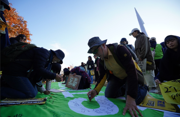 23일, 전 세계 시민 1,000여 명과 16개 환경단체로 구성된 ‘플뿌리연대’가 벡스코를 중심으로 ‘강력한 국제 플라스틱 협약을 위한 1123 시민행진’에 나선 가운데, 행진 도착점에서 시민들이 ‘플라스틱, 이제 그만(No More Plastic)’ 메시지 현수막에 손도장을 찍고 있다. /사진=플뿌리연대