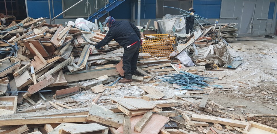 재활용 공장에 들어온 폐목재에서 가연성 쓰레기를 선별하고 있다. 
