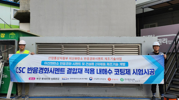 롯데건설 직원들이 부산 롯데타워 현장에서 이산화탄소 반응경화 시멘트를 활용한 코팅제를 시공하고 기념촬영을 하고 있다. /사진제공=롯데건설