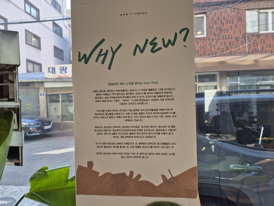 “Why New?”라는 문구가 쓰인 포스터가 카페 창문에 붙어 있다. 여기엔 진정한 환경보호의 의미, 중고 제품의 가치, 원써드의 환경적 가치 등을 포함하고 있다. /사진=김태현 객원기자
