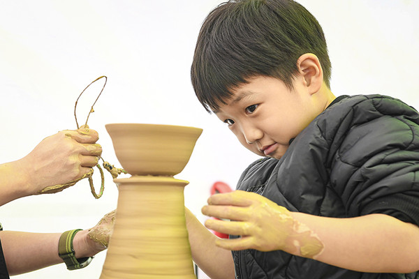 축제장을 찾은 한 어린아이가 문경 찻사발 빚기 체험장에서 물레를 돌리며 흙을 빚고 있다. /사진제공=문경시