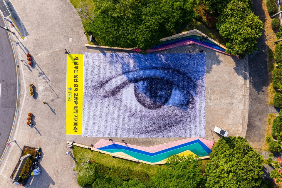 플뿌리연대는 ‘2025 세계 환경의 날’ 기념 행사가 시작된  4일 제주 국제컨벤션센터 앞에서 ‘강력한 플라스틱 협약’을 요구하기 위해 눈이 그려진 #WeAreWatching 초대형 깃발을 펼치는 퍼포먼스를 진행했다. /사진제공=그린피스