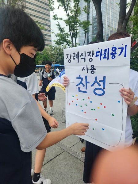학생이 장례식장 다회용기 사용 찬성에 스티커를 붙이고 있다. /사진제공=(사)자원순환사회연대