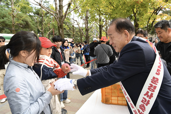신현국 시장이 문경사과축제장을 찾은 관광객들에게 감홍사과를 나눠 주고 있다. /사진제공=문경시
